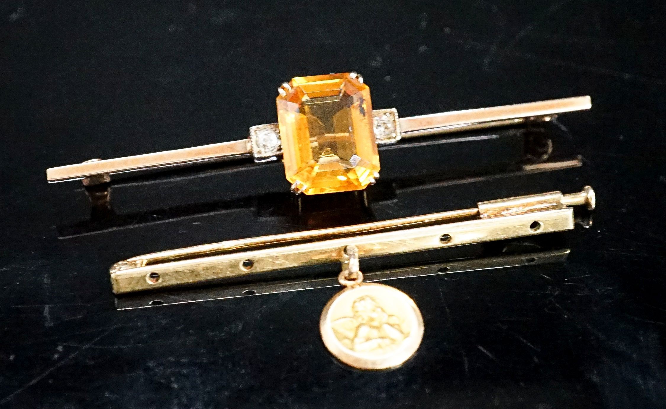 A yellow metal, single stone citrine and two stone diamond set bar brooch, 56mm and one other with cherub pendant charm, gross 6.3 grams.